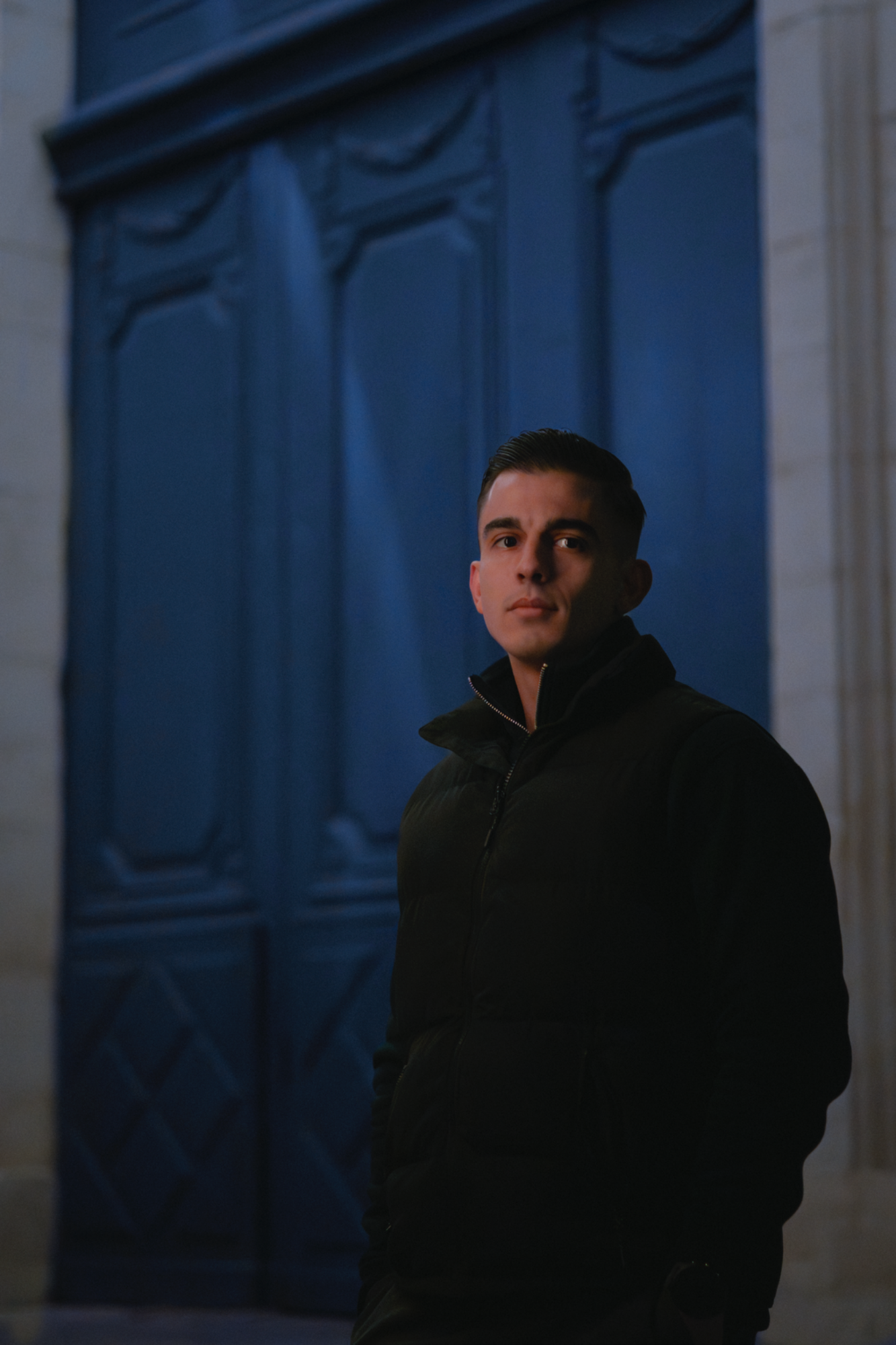 Jeune garçon posé et souriant dans un rayon de soleil à l’intérieur – portrait naturel par Luminéo