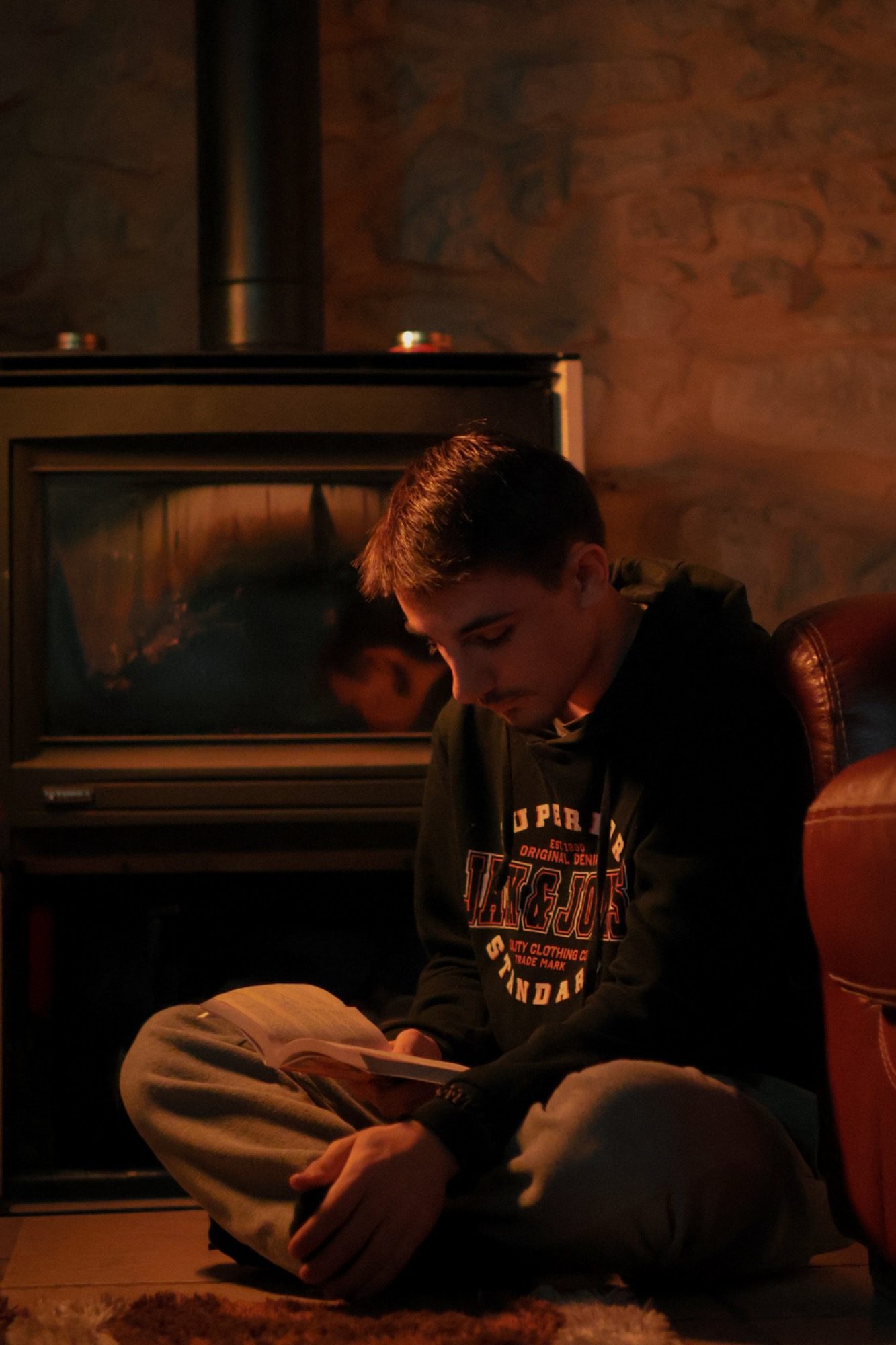 Jeune garçon posé et souriant dans un rayon de soleil à l’intérieur – portrait naturel par Luminéo